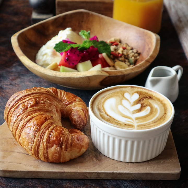 Frühstück mit Kaffee, Croissant und Müslibowl